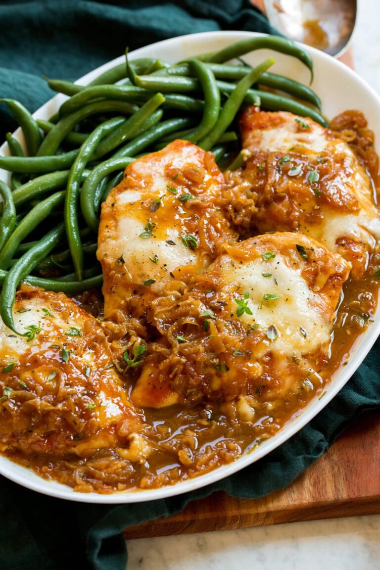 French onion chicken served on a white platter with green beans.